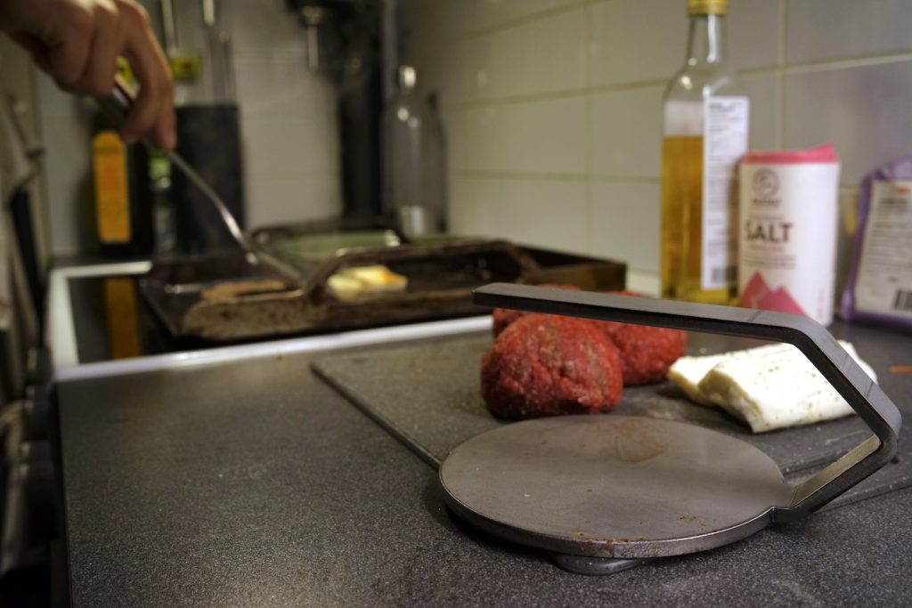 närbild på smashjärn från bluegaz med smashburgers i bakgrunden