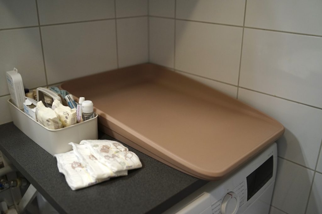 bild på twistshake skötbädd i rosa ovanpå tvättmaskin med babytillbehör